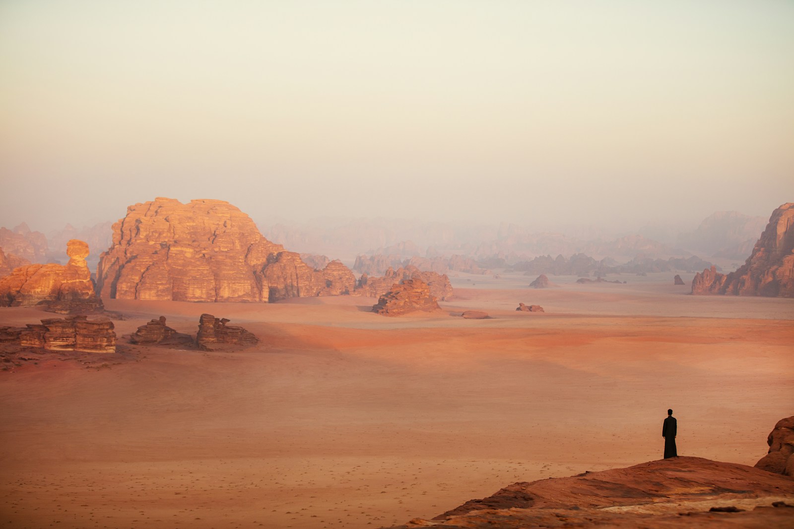 a lone person standing in the middle of a desert