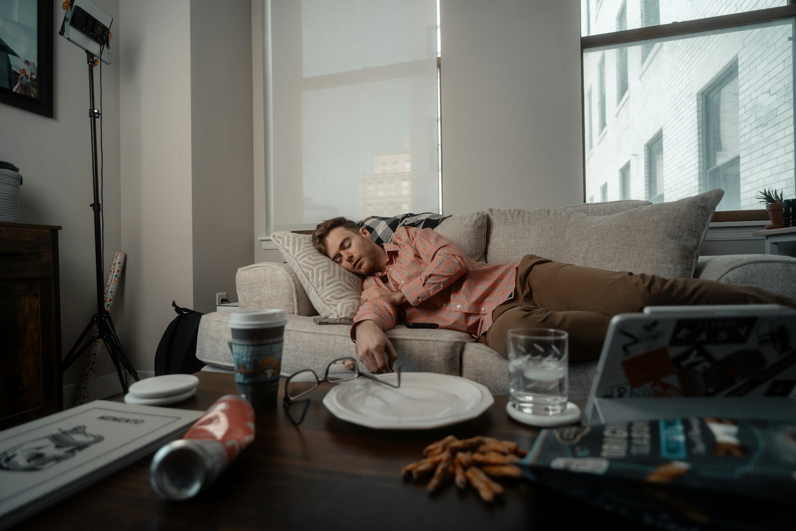 a woman laying on a couch with a plate of food