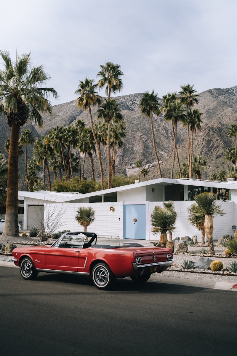 a red convertible car parked in front of a house