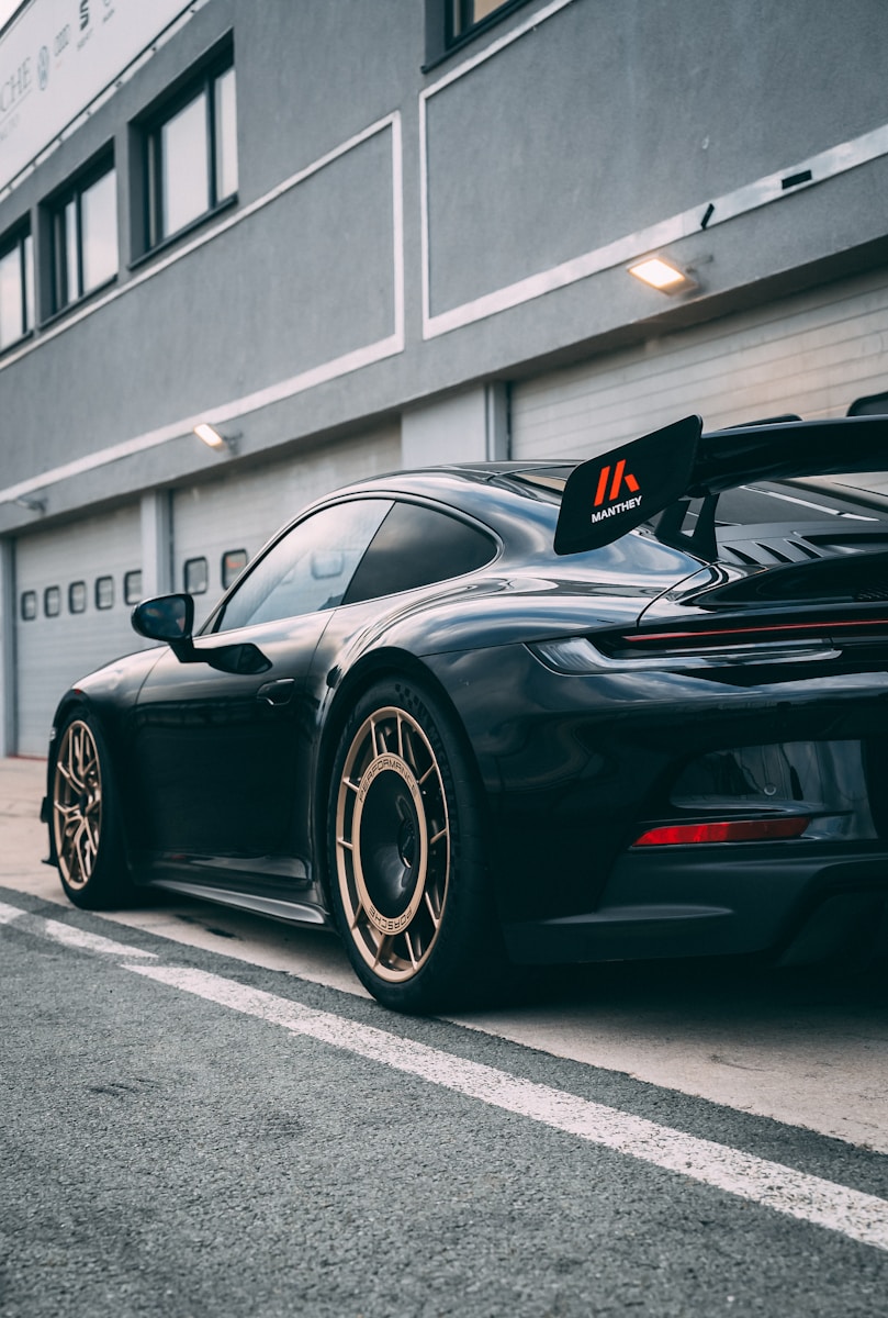 a black sports car parked in front of a building